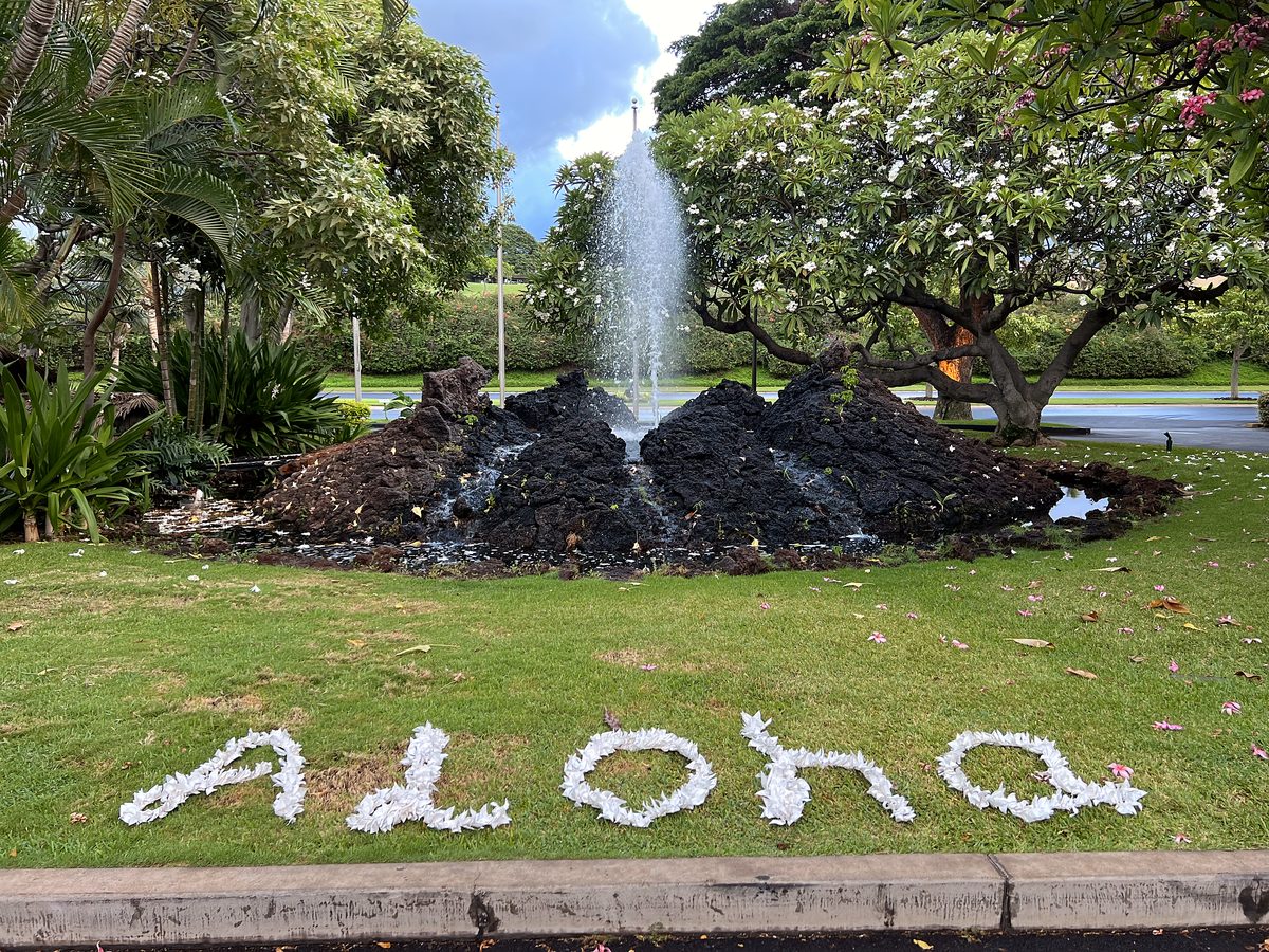 An Aloha sign and fountain at a resort entrance