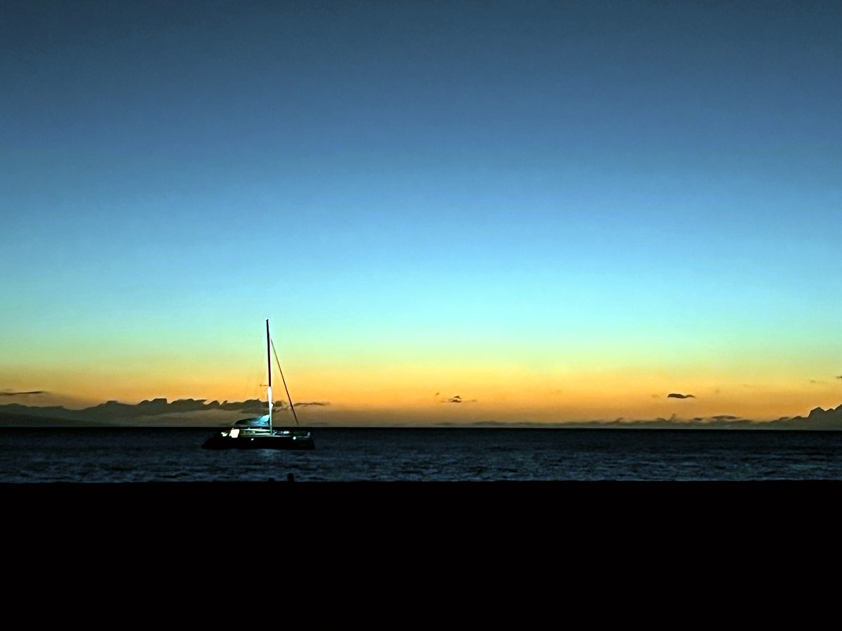A catamaran on the horizon at dusk